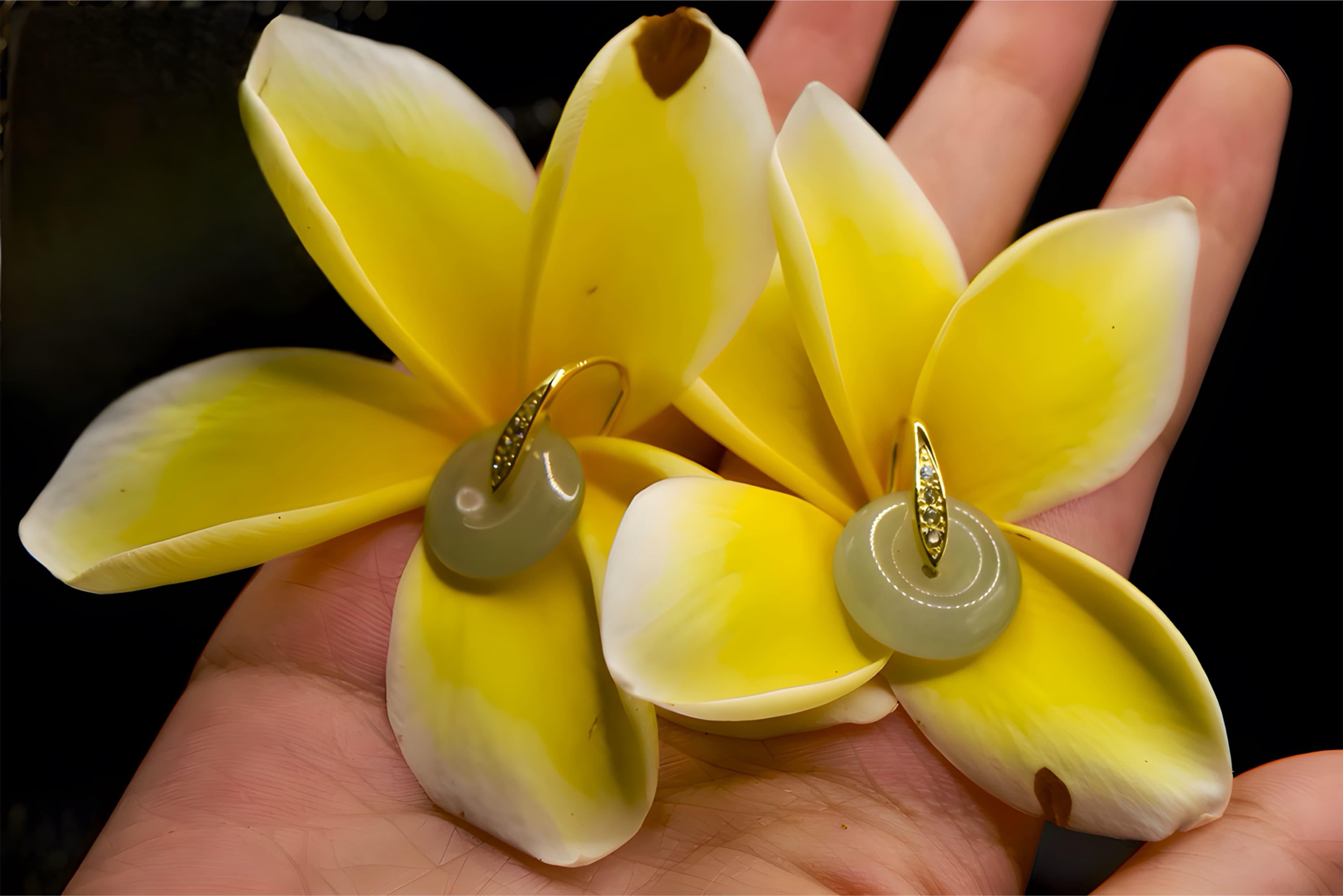 Hand holding a jade pendant — soft daylight, silk backdrop